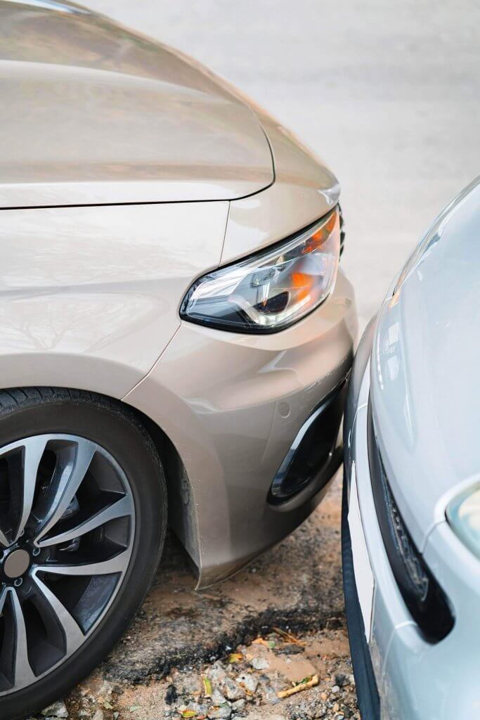 Zwei Autos stehen Stoßstange an Stoßstange auf unebenem Boden, optimal positioniert für ein Schadengutachten