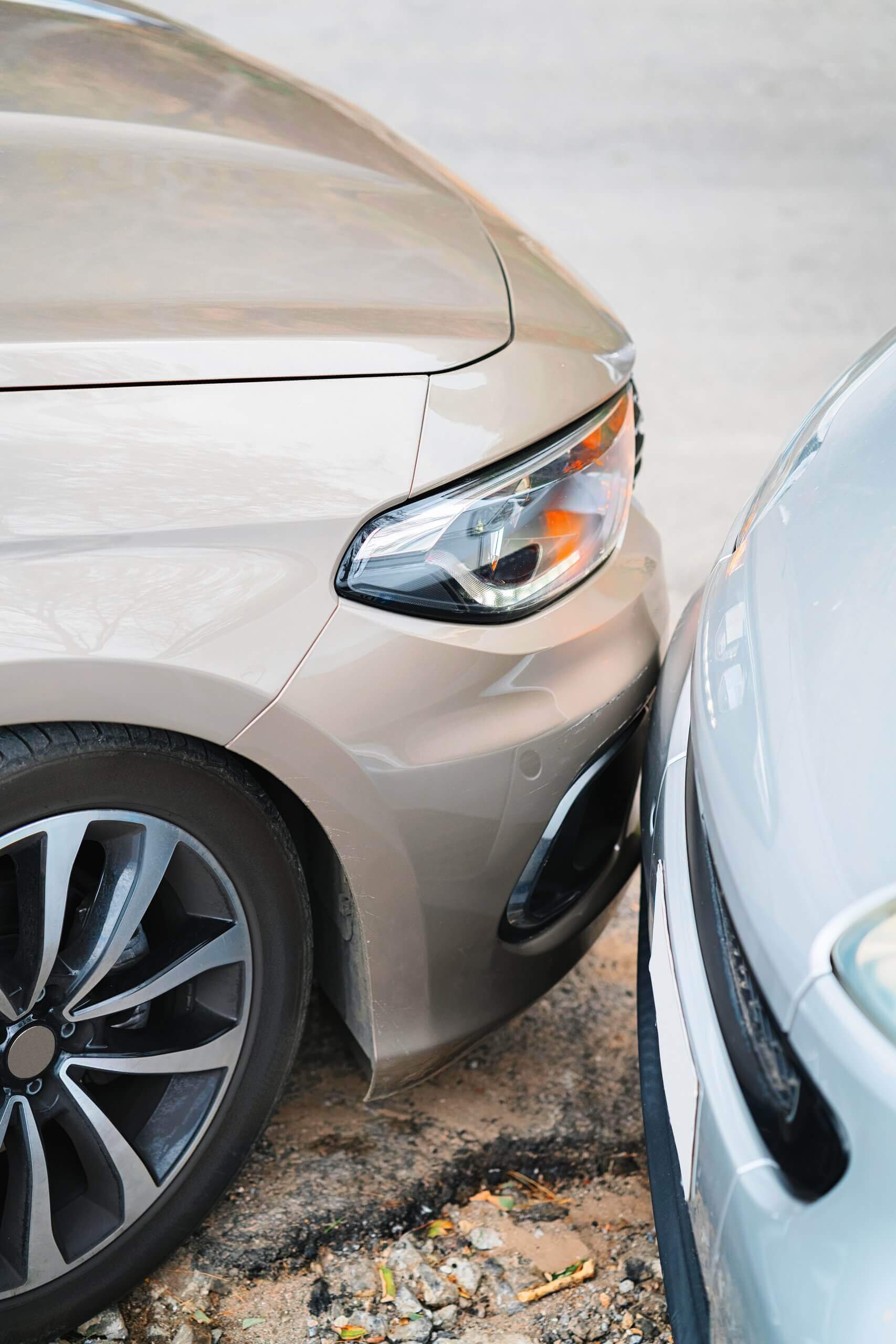 Zwei Autos stehen Stoßstange an Stoßstange auf unebenem Boden, optimal positioniert für ein Schadengutachten
